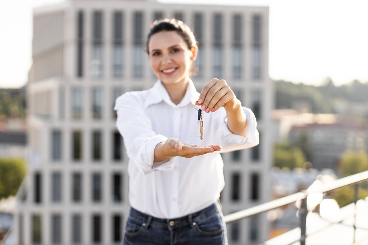 Immobilienexpertin übergibt Schlüssel nach erfolgreichem Verkauf